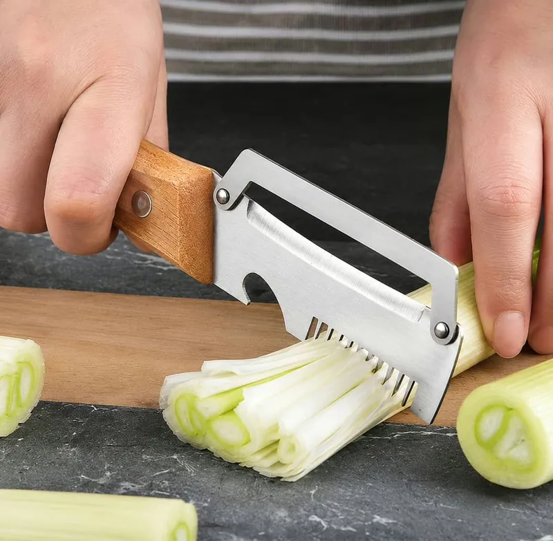 PeelPro posé sur une planche en bois à côté de fines lamelles de poireau taillées en julienne
